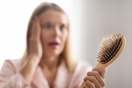 Hairloss Problem. Shocked Mature Woman Looking At Comb Full Of Fallen Hair At Home, Stressed Middle Aged Female Holding In Hand Bamboo Brush With Lock Of Hair , Suffering Alopecia, Selective Focus